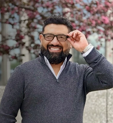 Eduardo Camargo sonriendo frente a una casa vendida con las llaves en la mano